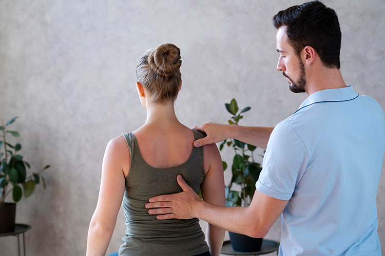 Physiotherapeut übt Druck auf Rücken aus
